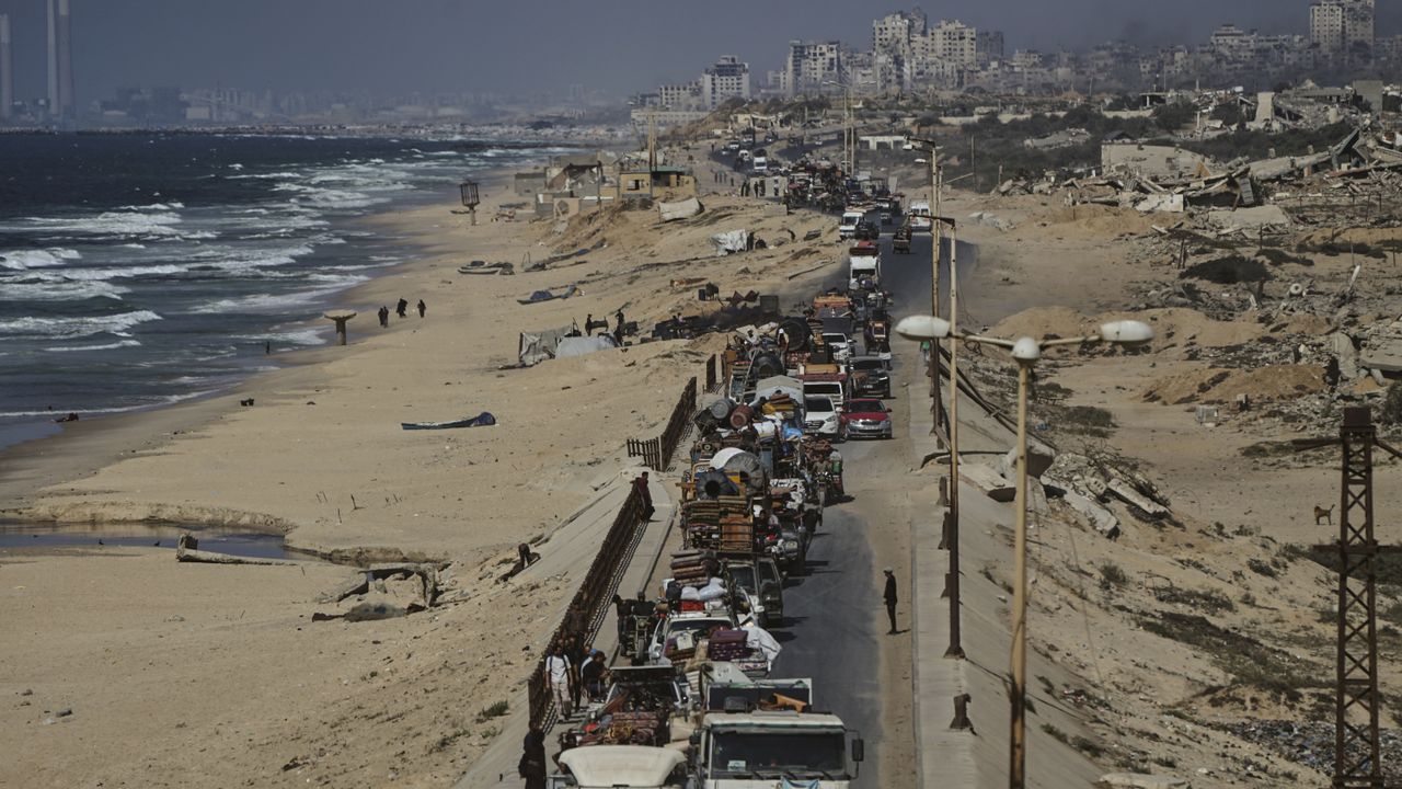 Displaced Palestinians fleeing northern Gaza carry their belongings along the coastal road toward southern Gaza, Tuesday, Sept. 9, 2025, after the Israeli army issued evacuation orders from Gaza City. [AP Photo/Jehad Alshrafi]